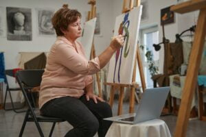 Attentive aged woman spending weekend in art studio