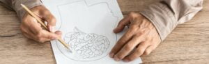 panoramic shot of retired man with alzheimer disease drawing human head and brain